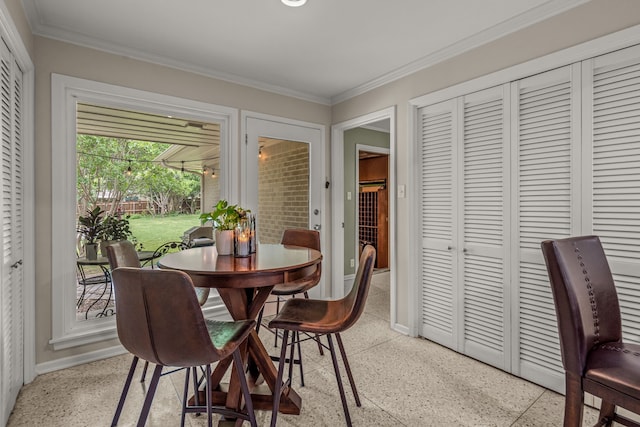 dining space with light speckled floor, baseboards, and ornamental molding