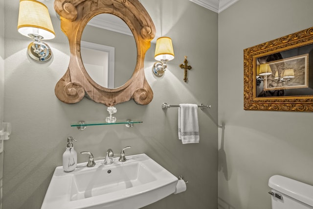 half bath with a sink, toilet, and ornamental molding