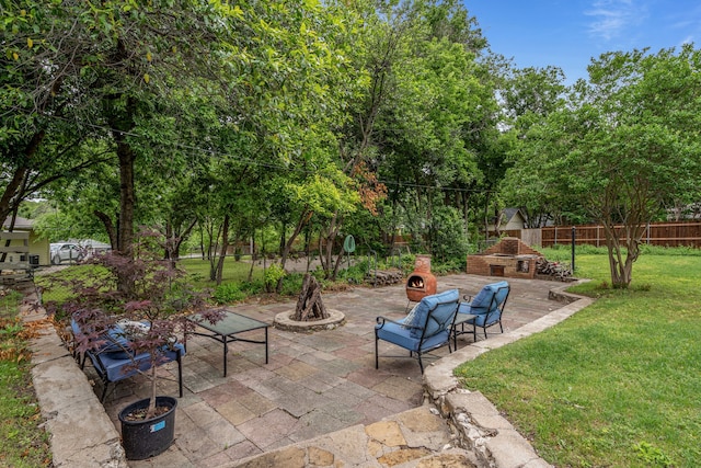 view of patio / terrace featuring an outdoor stone fireplace and a fenced backyard