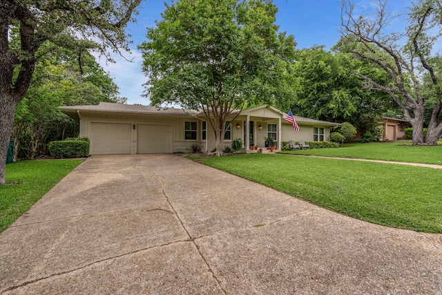 single story home featuring covered porch, an attached garage, driveway, and a front lawn