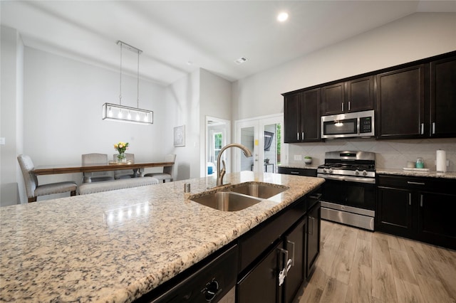616 Chippewa Way, Aubrey, TX 76227 - kitchen with stainless steel appliances, a sink, tasteful backsplash, light stone countertops, and light wood-style flooring