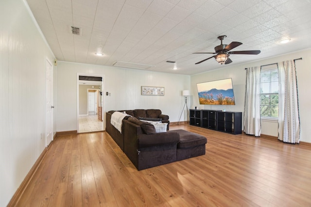 living room with attic access, hardwood / wood-style flooring, ceiling fan, baseboards, and visible vents