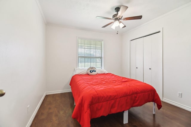 bedroom with baseboards, crown molding, wood finished floors, and a closet
