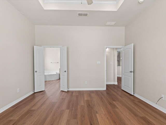 unfurnished bedroom with wood finished floors, visible vents, and baseboards