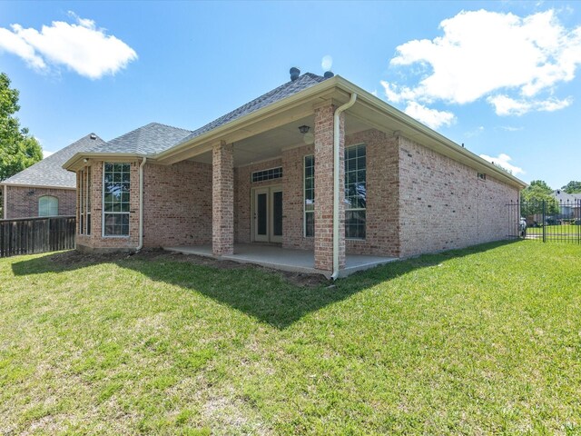 rear view of property with a lawn, fence, and a patio