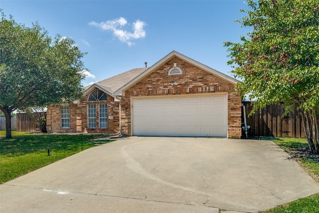 view of front of home featuring concrete driveway, fence, brick siding, a garage, and a front yard