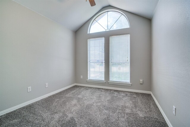 carpeted empty room featuring lofted ceiling, a ceiling fan, and baseboards