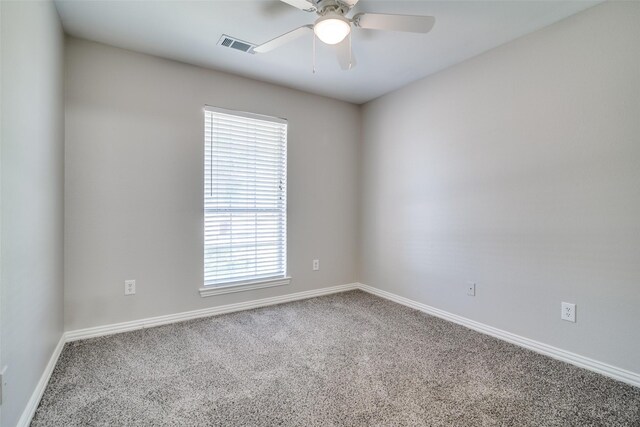 carpeted empty room with visible vents, a ceiling fan, and baseboards