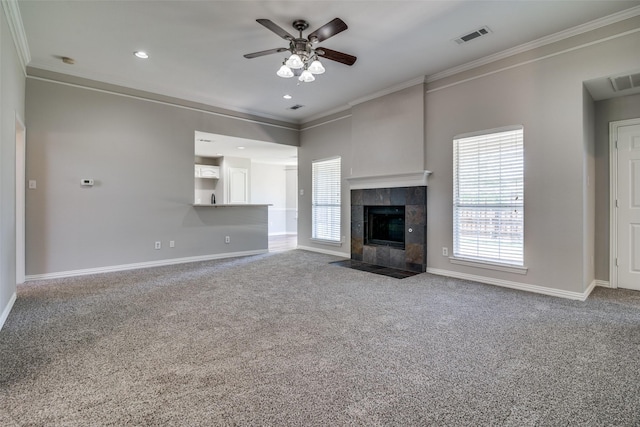 unfurnished living room with a wealth of natural light, baseboards, ceiling fan, crown molding, and carpet floors