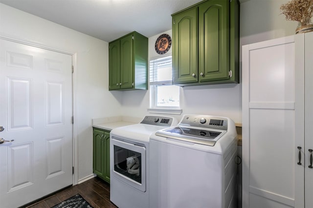 laundry area with washing machine and clothes dryer, dark wood-type flooring, and cabinet space