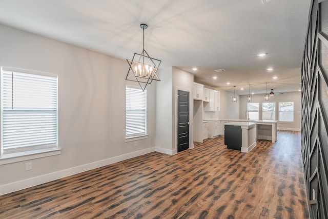 4550 Luzon St, Dallas, TX 75216 - kitchen featuring an island with sink, baseboards, dark wood-style floors, and recessed lighting