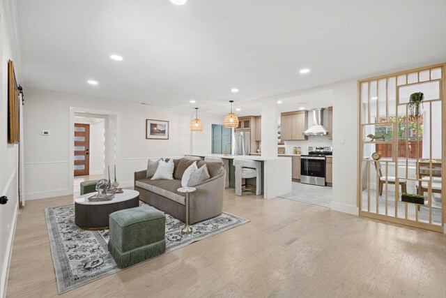 living room featuring light wood finished floors, baseboards, and recessed lighting