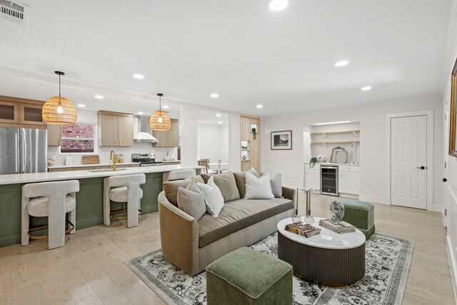 living area featuring visible vents, light wood-style flooring, wine cooler, and recessed lighting