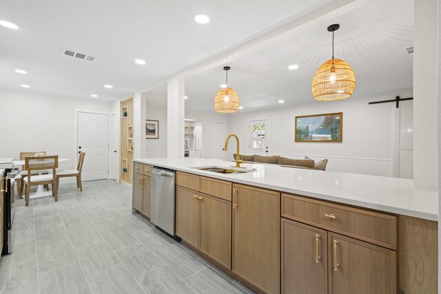 kitchen featuring a barn door, dishwasher, visible vents, a sink, and open floor plan