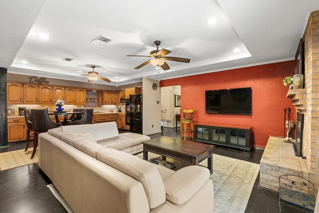 living room featuring a ceiling fan, hardwood / wood-style floors, a raised ceiling, visible vents, and recessed lighting