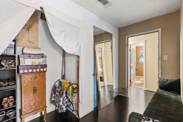interior space featuring baseboards, wood finished floors, and visible vents