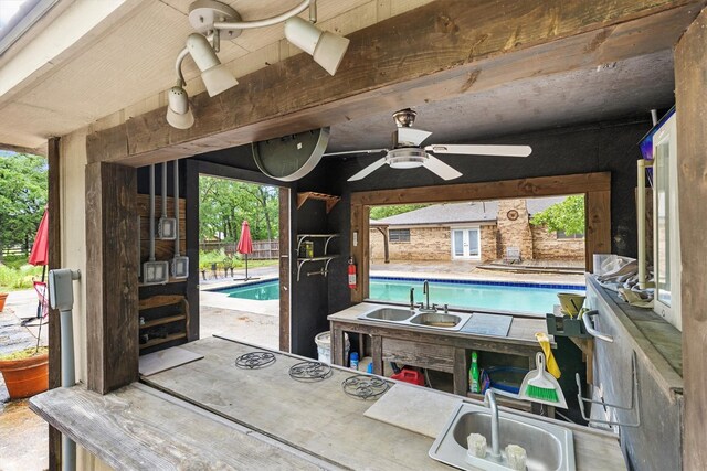 view of patio featuring a sink, an outdoor pool, and ceiling fan