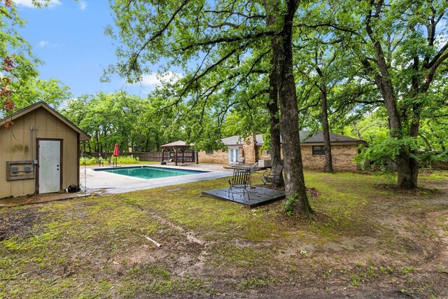 pool featuring a gazebo, an outbuilding, a patio, and fence