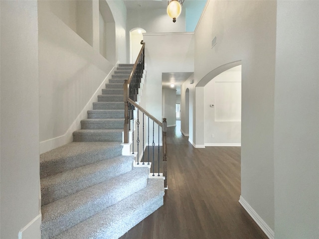 1005 Lake Hollow Dr, Little Elm, TX 75068 - entrance foyer with stairs, baseboards, arched walkways, wood finished floors, and a high ceiling