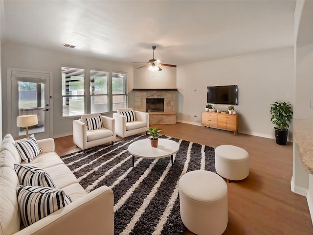1005 Lake Hollow Dr, Little Elm, TX 75068 - living room with wood finished floors, visible vents, a ceiling fan, and a stone fireplace