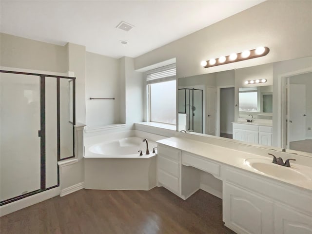 1005 Lake Hollow Dr, Little Elm, TX 75068 - bathroom with vanity, a stall shower, visible vents, a garden tub, and wood finished floors