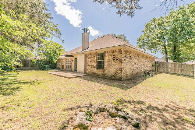 1944 Nottingham Dr, Kaufman, TX 75142 - rear view of property featuring a patio area, a chimney, a fenced backyard, a yard, and brick siding