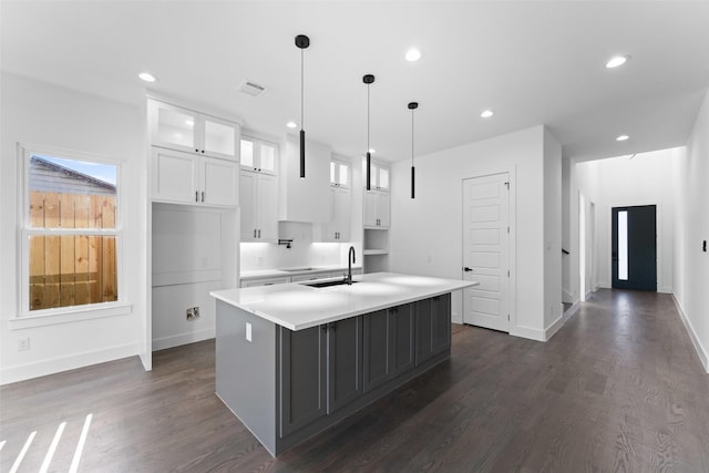 1822 Bickers St, Dallas, TX 75212 - kitchen featuring a center island with sink, white cabinets, glass insert cabinets, dark wood-type flooring, and light countertops