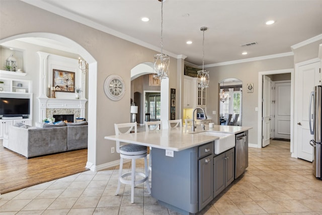 kitchen with stainless steel appliances, a breakfast bar, visible vents, light tile patterned floors, and a sink