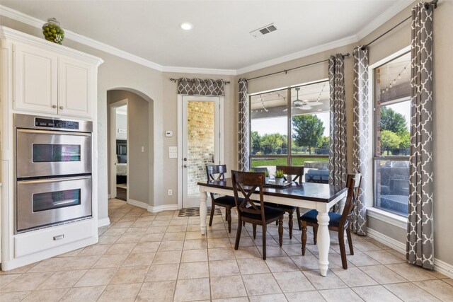 dining space with baseboards, visible vents, arched walkways, and light tile patterned floors
