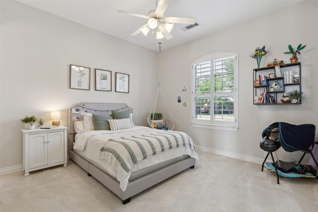 bedroom with visible vents, baseboards, and light carpet