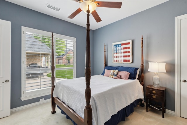 bedroom featuring light colored carpet, baseboards, a ceiling fan, and visible vents