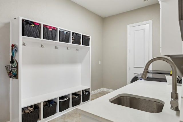mudroom with baseboards and a sink