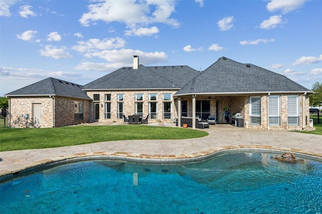 pool with a lawn and a patio area