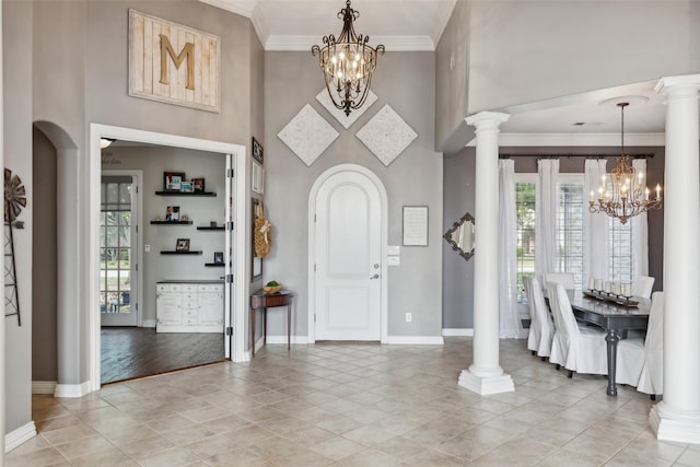 entryway featuring a high ceiling, ornamental molding, a chandelier, and a wealth of natural light