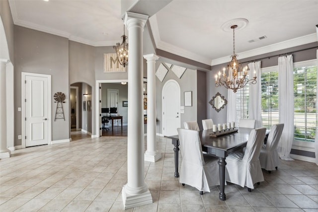 dining area featuring crown molding, arched walkways, an inviting chandelier, baseboards, and visible vents