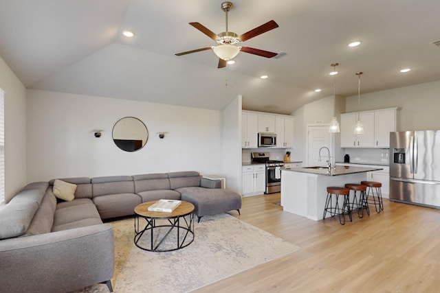 living room featuring light wood-type flooring, vaulted ceiling, visible vents, recessed lighting, and a ceiling fan