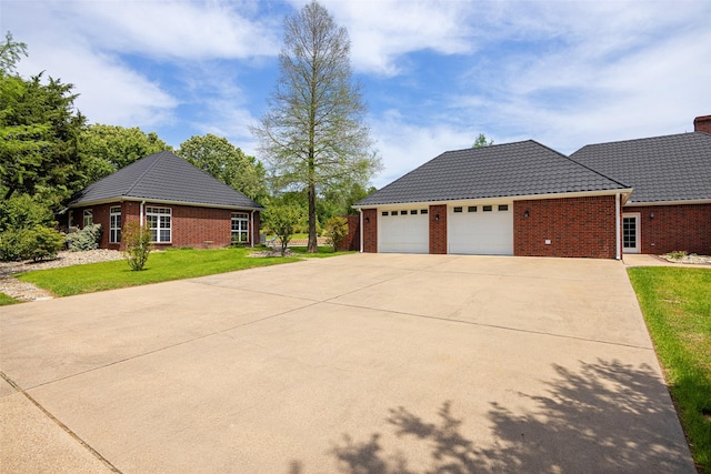 view of property exterior with brick siding, a yard, driveway, and a garage