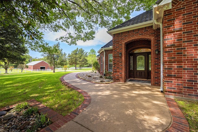 property entrance featuring brick siding and a yard