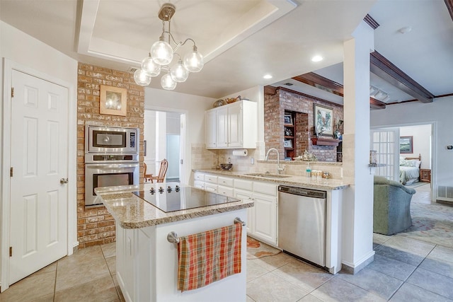 kitchen featuring a sink, white cabinetry, appliances with stainless steel finishes, light stone counters, and light tile patterned floors