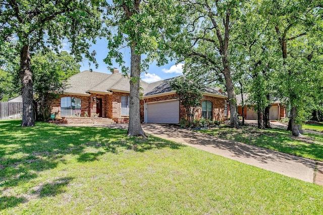 single story home featuring a garage, driveway, fence, a front yard, and brick siding