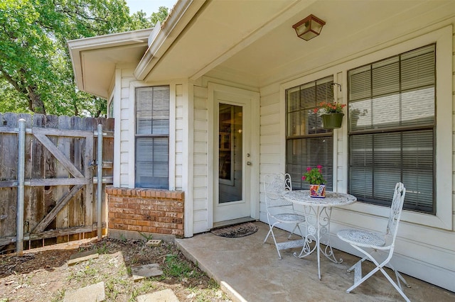 entrance to property with a porch and fence