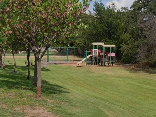 community play area with fence and a lawn