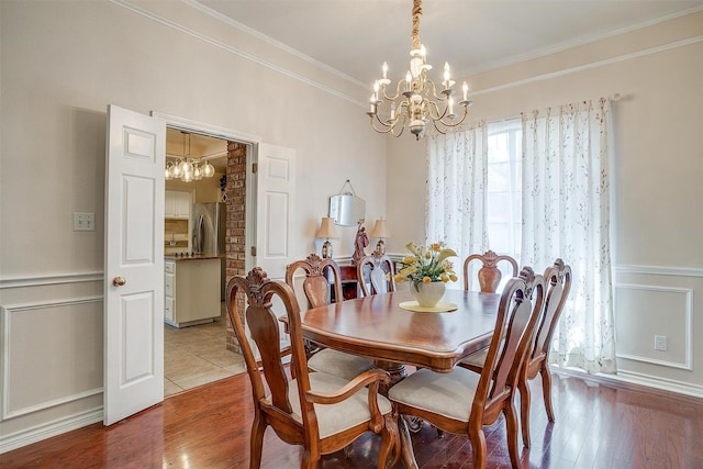 dining room with crown molding, wood finished floors, and a chandelier