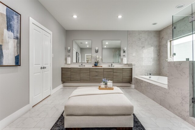 bathroom with recessed lighting, marble finish floor, double vanity, a sink, and a bath