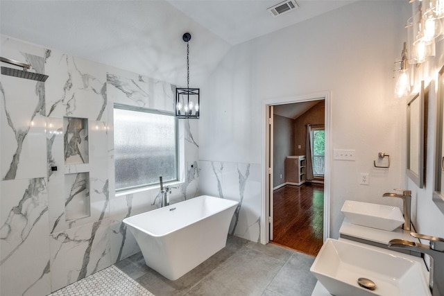604 Lake Village Dr, Mckinney, TX 75071 - full bathroom with a sink, a freestanding bath, a chandelier, lofted ceiling, and tile walls