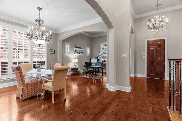 dining room with hardwood / wood-style flooring, arched walkways, a notable chandelier, and crown molding