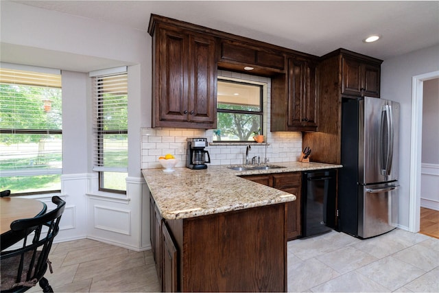 129 Highland Dr, Aledo, TX 76008 - kitchen featuring dark brown cabinets, light stone countertops, a sink, freestanding refrigerator, and black dishwasher