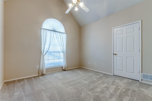 unfurnished room featuring carpet, ceiling fan, baseboards, lofted ceiling, and visible vents