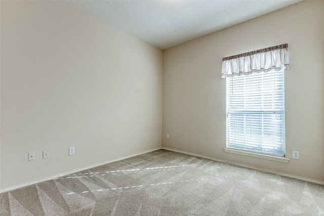 unfurnished room with baseboards and carpet floors