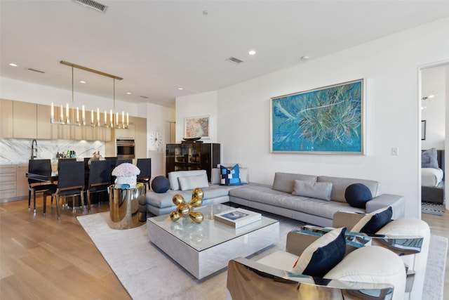 2200 Victory Ave Unit 2003, Dallas, TX 75219 - living room featuring light wood-style floors, recessed lighting, and a chandelier